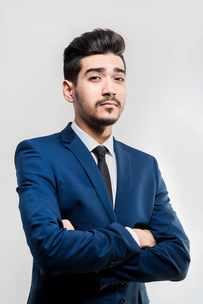 Young attractive man in a blue suit on a gray background. Isolated - Foto, imagen