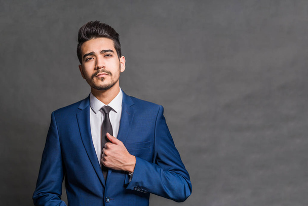 Young attractive man in a blue suit on a gray background - Фото, зображення