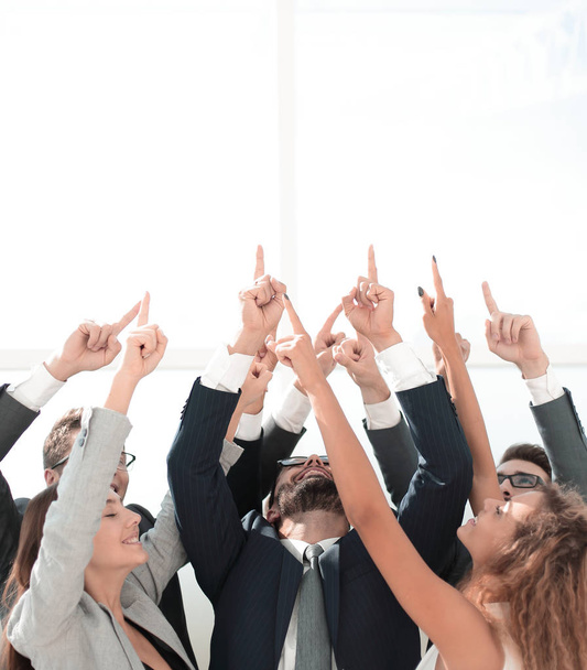 business team standing in a circle and pointing up - Photo, image