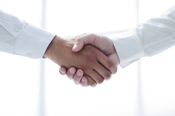 close up.handshake of business people on a light background - 写真・画像