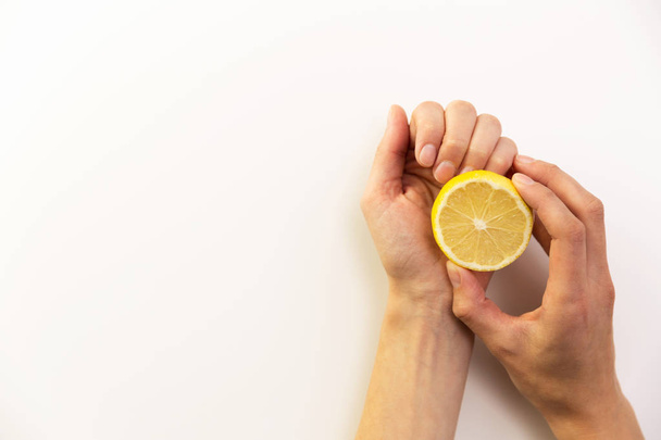 Manicure, woman cleans her nails with lemon. - Фото, изображение