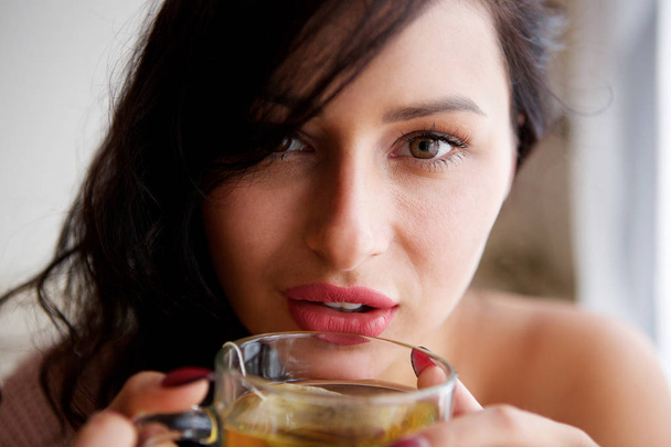 Nahaufnahme Porträt einer Frau zu Hause mit gesundem warmen Tee - Foto, Bild