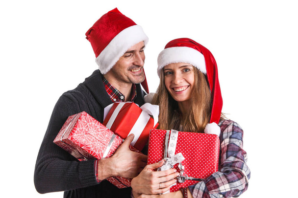 Happy beautiful couple holding many christmas gifts isolated on white background - 写真・画像