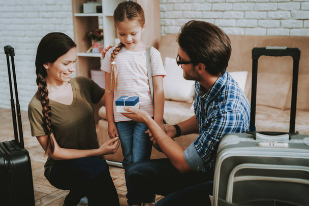 Parents Give Gift. Smiling Little Girl. Smiling Family at Home. Smiling Person. Family with Child. New Bright Apartment. People in New Bright Apartment. Parents and Dougther. Person with Suitcases. - Fotoğraf, Görsel