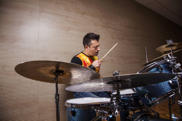 joven percusionista ensayando tocando la batería en el estudio de ensayo
 - Foto, imagen