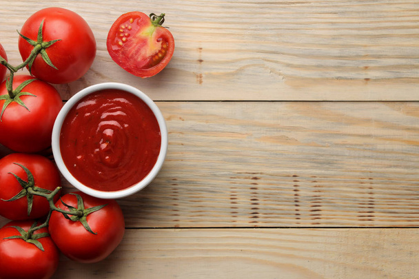 Rode saus in een kom met verse ingrediënten, tomaten op een natuurlijke houten tafel. Bekijk van bovenaf. met ruimte voor een inscriptie - Foto, afbeelding