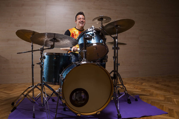 молодой перкуссионист репетирует на барабанах в репетиционной студии
 - Фото, изображение