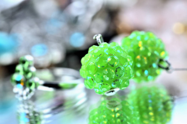 Close-up of green earrings jewelery - reflection effect - colored backgrounds - Photo, Image