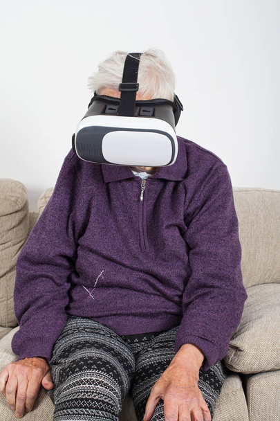Elderly retired woman experiencing virtual reality video with headset - Foto, immagini