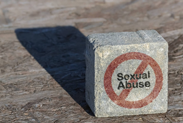 Κείμενο σεξουαλικής κακοποίησης και περιορισμός σύμβολο γραμμένο σε μια πέτρινη πλατεία κοντά - Φωτογραφία, εικόνα