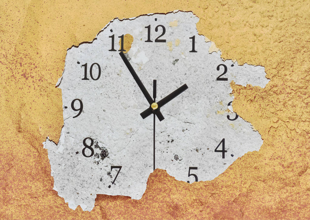 große Uhr an einer gelben Schälwand, die die Uhrzeit anzeigt - Foto, Bild