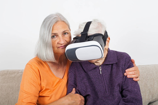 Elderly women experiencing virtual reality video with headset - Фото, зображення
