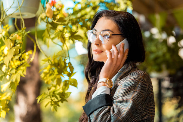 красивая стильная женщина в очках разговаривает на смартфоне
 - Фото, изображение