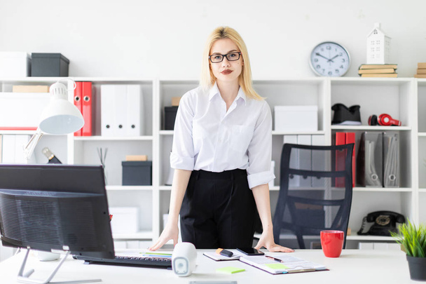 young businesswoman  standing in the office at the computer table.  - Фото, изображение
