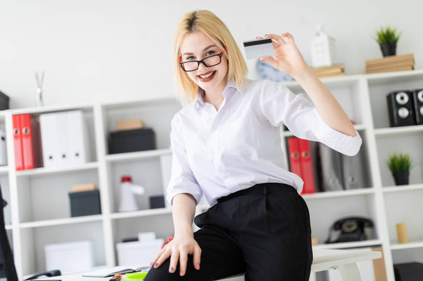 young businesswoman in  the office, holds a credit card  - Fotoğraf, Görsel