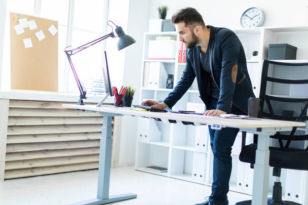 Ein smarter junger Mann arbeitet in einem hellen Büro  - Foto, Bild
