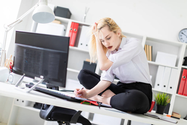 уставшая деловая женщина сидит на столе в офисе
.  - Фото, изображение