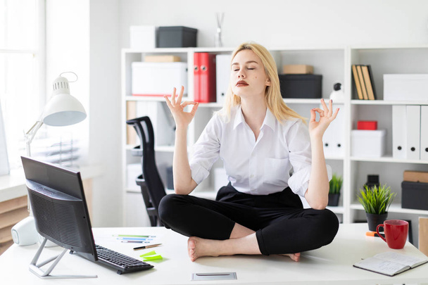 young businesswoman sitting and meditating on a table in the office. - Foto, immagini