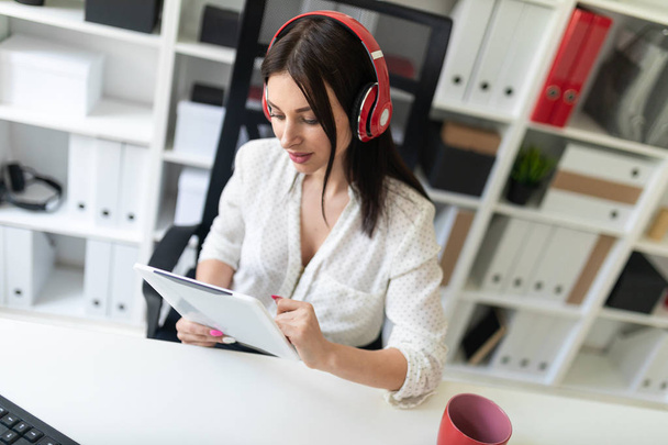 young businesswoman in the office with headphones and tablet pc - Photo, image