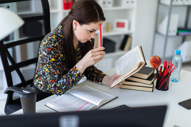 mulher de negócios não distraída lendo livro de lei enquanto sentado na mesa em escritório brilhante
  - Foto, Imagem