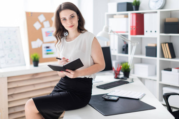 Beautiful young businesswoman with phone  in a bright office.  - Photo, Image