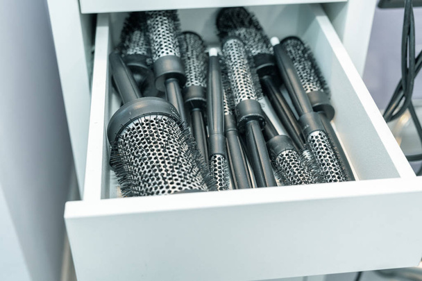 Drawer of hairbrushes in a beauty salon. - Фото, изображение