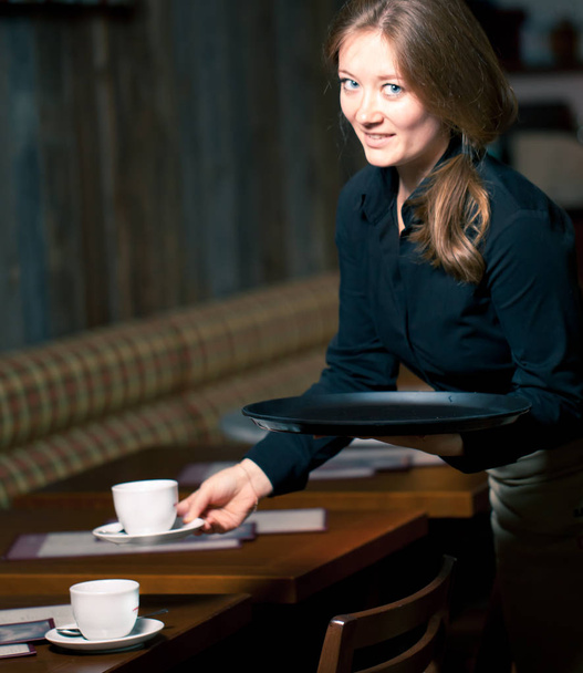 Portrait of waitress holding tray of coffee cups in cafe - Фото, зображення