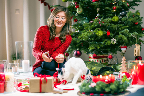 Woman Wrapping and Decorating Christmas Present - Photo, image