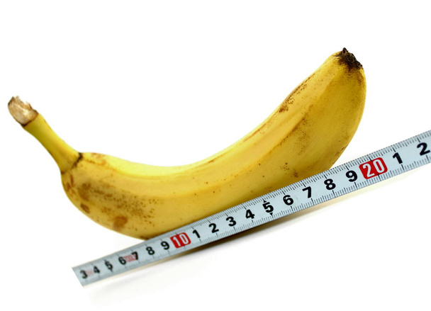 Grande banane et ruban à mesurer sur fond blanc
 - Photo, image