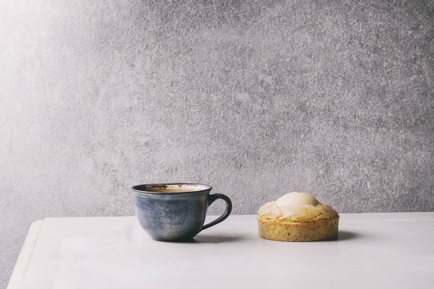 Sweet pear tartlet with cup of coffee espresso standing on white marble table with grey wall at background. Minimalist style. Copy space - Foto, immagini