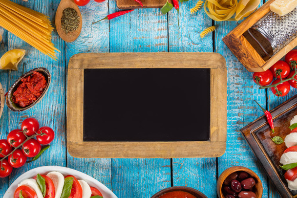 Various kind of italian food served on wood with blackboard. Top view, free space for text - Fotoğraf, Görsel