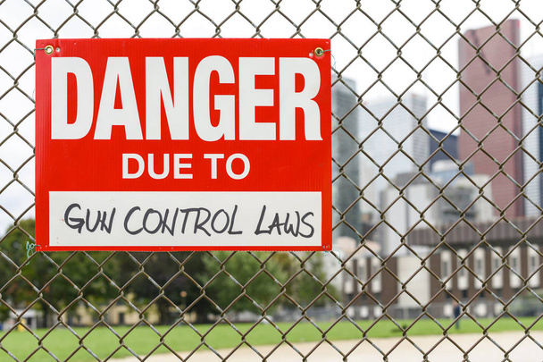 Firme el peligro debido a las leyes de control de armas adjuntas en la valla en la parte delantera de la ciudad
 - Foto, imagen