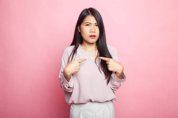 Joven asiática mujer apuntar a sí misma preguntar por qué me en rosa fondo
 - Foto, Imagen