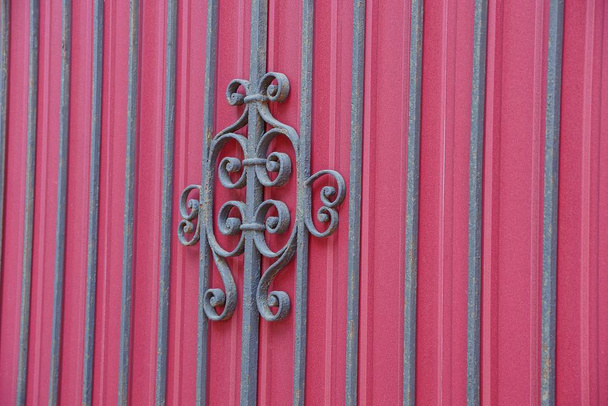 текстура чорних сталевих стрижнів і кований візерунок на стіні з червоного металу
 - Фото, зображення