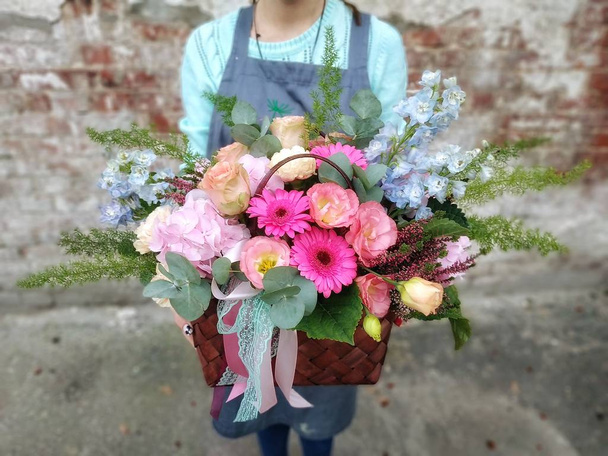 Strauß - Blumen und Pflanzen in der Tasche, Nahaufnahme. Florist im Blumenladen - Foto, Bild