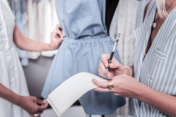 Fashion designer wearing striped vest and nice accessories making some notes - Φωτογραφία, εικόνα