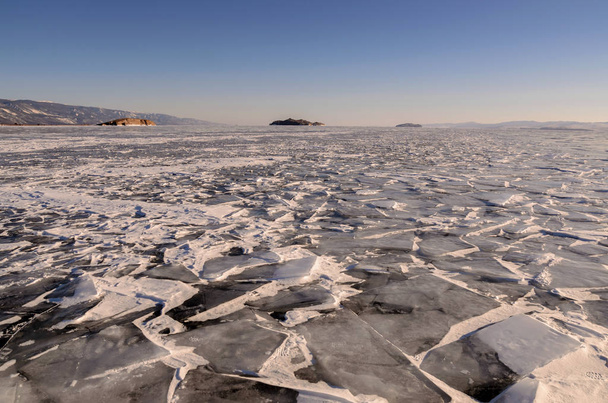 Field of ice hummocks on the frozen Lake Baikal with mointain. Russia - Foto, imagen