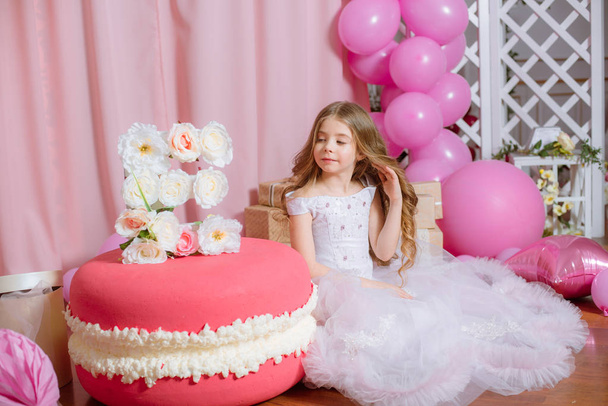 Little girl with blond long hair celebrate Happy Birthday Party with rose decor and  balloons  - Foto, afbeelding