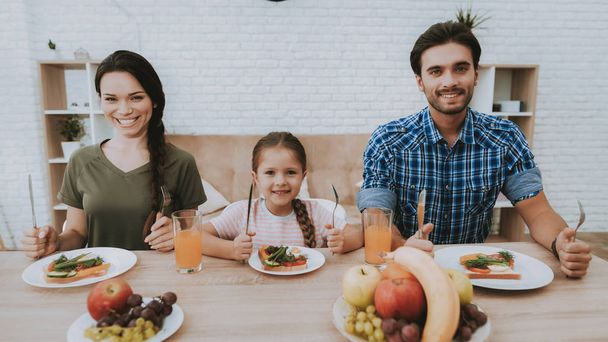 Man Cooking. Family Having Breakfast. Family at Table. Fruit on Plate. Sandwich on Plate. White Plate. Juice in Glass. Food on Table. Happy Family. Smiling People. Vegetables on Bread. White Interior. - Foto, imagen