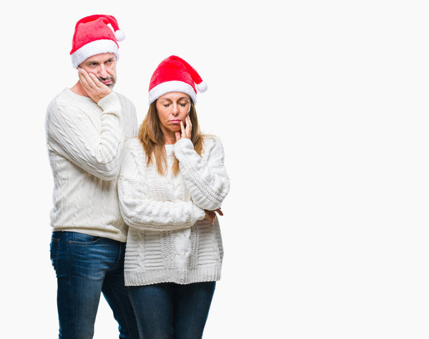 Orta yaş İspanyol çift seyir yorgun ve bıkkın ile depresyon sorun Çapraz kollar ile izole arka plan düşünme üzerinde Noel şapka. - Fotoğraf, Görsel