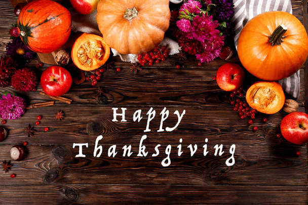 Happy thanksgiving concept. Still life composition with pumpkin and oher fruits and vegetble small decoration with funny font text white text. Wood textured table background. Top view, close up. - Photo, Image