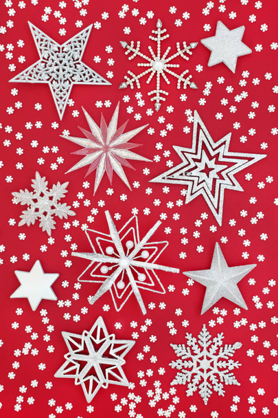 Weihnachtsstern und Schneeflocken-Christbaumschmuck auf rotem Hintergrund. Traditionelle Weihnachtsgrußkarte für die Weihnachtszeit. - Foto, Bild