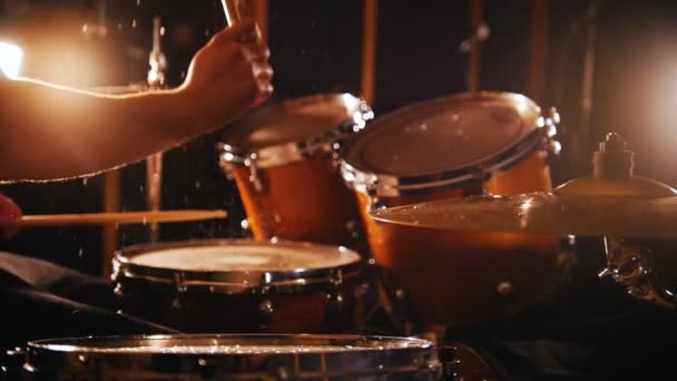 Барабанщик играет музыку на мокрых барабанах в студии в гараже
. - Кадры, видео
