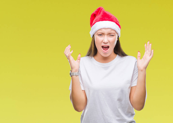 Mladá krásná Kavkazský žena nosí vánoční čepice nad, samostatný, pozadí slaví mad a crazy pro úspěch s pažemi, vystouplý a zavřené oči křik nadšeni. Vítěz koncept - Fotografie, Obrázek