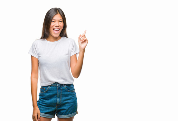 Mladá asijská žena izolované pozadí ukazující prst s úspěšným myšlenkou. Byl ukončen a šťastný. Číslo jedna. - Fotografie, Obrázek