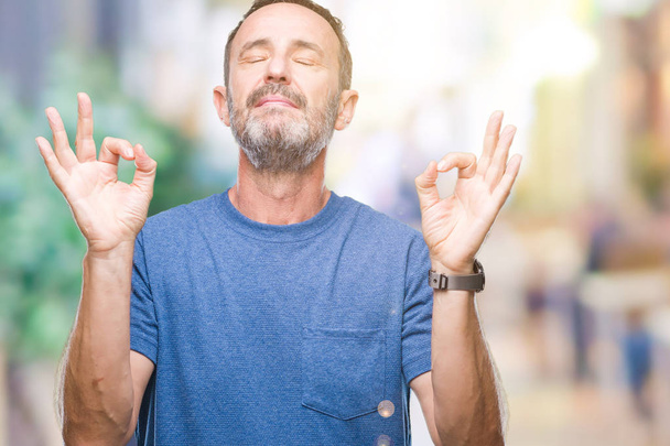 Старший чоловік середнього віку над ізольованим тлом розслабляється і посміхається очима, закритими роблячи медитаційний жест пальцями. концепція йоги
. - Фото, зображення