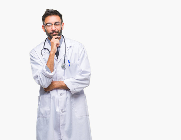 Dospělé hispánský lékař muž nad izolované pozadí sebevědomým na kameru s úsměvem se zkříženýma rukama a ruku a na bradě. Pozitivní myšlení. - Fotografie, Obrázek