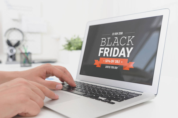 Man using laptop with Black Friday promotion sale on screen - Foto, afbeelding