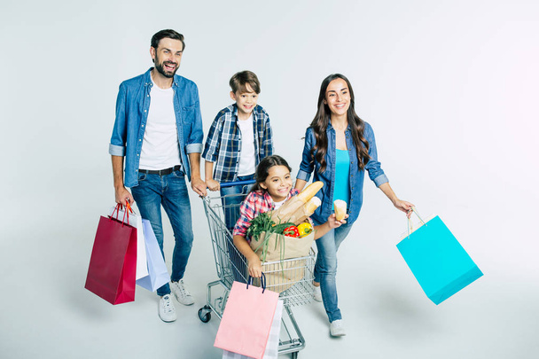 young caucasian family with shopping bags on white background, shopping concept  - Zdjęcie, obraz