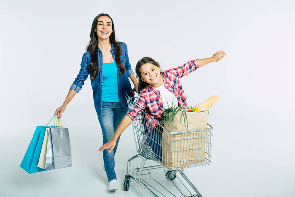 Mother and daughter with shopping bags on white background, shopping concept - Foto, Imagem